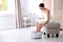Woman with beautiful legs using foot bath at home, space for text. Spa treatment