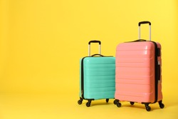 Stylish suitcases on color background. Space for text