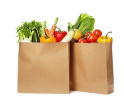 Paper bags with fresh vegetables on white background