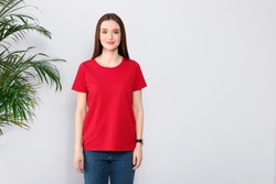Young woman in t-shirt near light wall. Mock up for design