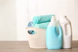 Basket with clean towels and detergents on table. Space for text