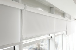 Modern window with white roller blinds indoors