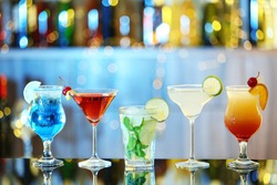 Glasses of fresh alcoholic cocktails on bar counter