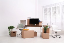 Cardboard boxes and packed belongings in office. Moving day
