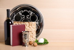 Symbolic Pesach (Passover Seder) items on wooden table, space for text