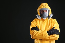 Man wearing chemical protective suit on black background, space for text. Virus research