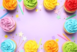 Colorful birthday cupcakes on lilac background, flat lay. Space for text