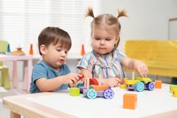 Little children playing with construction set at table