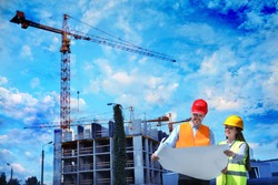 Construction crane and unfinished building against blue sky. Space for text