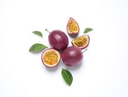 Fresh ripe passion fruits (maracuyas) with leaves on white background, flat lay