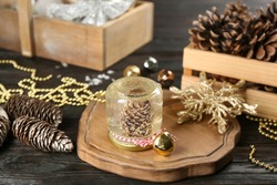 Handmade snow globe and Christmas decorations on black wooden table
