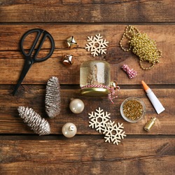 Set of instruments and materials for snow globe on wooden table, flat lay. Space for text