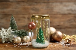 Handmade snow globe and Christmas decorations on wooden table