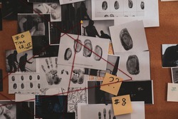 Detective board with crime scene photos, stickers, clues and red thread, closeup