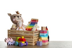 Set of different toys on wooden table against white background