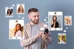 Handsome man visiting online dating site via smartphone on color background