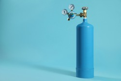 Medical oxygen tank on light blue background. Space for text