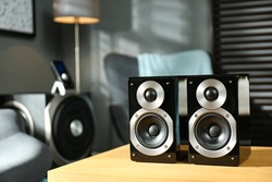 Modern audio speaker system on wooden table in living room