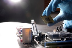 Technician repairing computer motherboard at table, closeup. Electronic device
