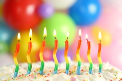 Birthday cake with burning candles on blurred background, closeup