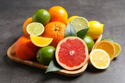 Different ripe citrus fruits on black table