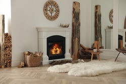 Beautiful fireplace and basket with firewood in contemporary room interior