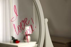Words I Love You written on mirror indoors
