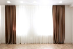 Windows with elegant curtains in modern room