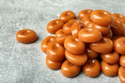 Tasty hard toffee candies on light grey table, closeup