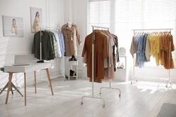 Modern boutique interior with stylish clothes and laptop