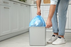 Man taking garbage bag out of bin at home, closeup