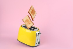 Bread slices popping up from modern toaster on pink background. Space for text