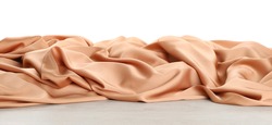 Beautiful peach silk on wooden table against white background