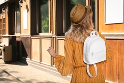Young woman with stylish backpack outdoors, back view