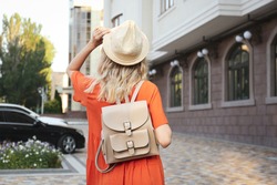 Young woman with stylish backpack outdoors, back view
