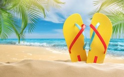 Yellow flip flops  on sandy beach near sea 