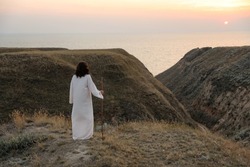 Jesus Christ on hills at sunset, back view. Space for text