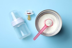 Flat lay composition with powdered infant formula on light blue background. Baby milk