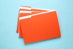 Orange files with documents on light blue background, top view