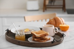 Wooden tray with delicious breakfast on white marble table in kitchen, space for text