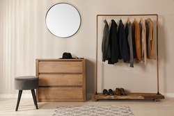 Modern dressing room interior with stylish clothes, shoes and mirror