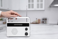 Woman with stylish white radio in kitchen, closeup. Space for text