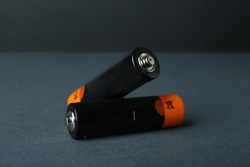 Two new AA batteries on dark background, closeup