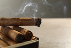 Many cigars in box on grey table, closeup. Space for text