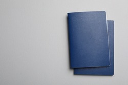 Blank blue passports on grey background, flat lay with space for text
