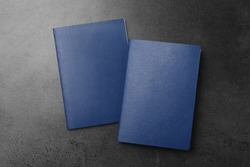 Blank blue passports on dark grey table, flat lay