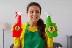 Woman showing bottles of toxic household chemical with warning signs, closeup