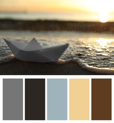 Color palette appropriate to photo of white paper boat on beach near sea at sunset