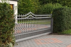 Grey metal gates near private house on street