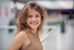 Portrait of beautiful teenage girl in shopping mall. Space for text